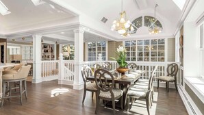 A spacious dining area with a high ceiling, large windows, and a chandelier. - West End Splendor by Snowmass Vacations (Aspen)