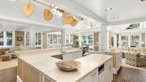 A spacious kitchen with a large island, white cabinetry, and a hanging light fixture. - West End Splendor by Snowmass Vacations (Aspen)