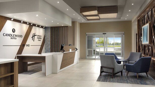 A reception area with a desk, chairs, and a view of the outdoors. - Candlewood Suites Chatham South by IHG (Chatham)