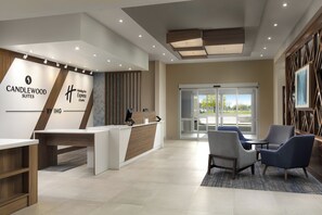 A reception area with a desk, chairs, and a view of the outdoors. - Candlewood Suites Chatham South by IHG (Chatham)
