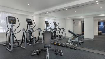 Un gimnasio con cintas de correr, elípticas y pesas sueltas.
