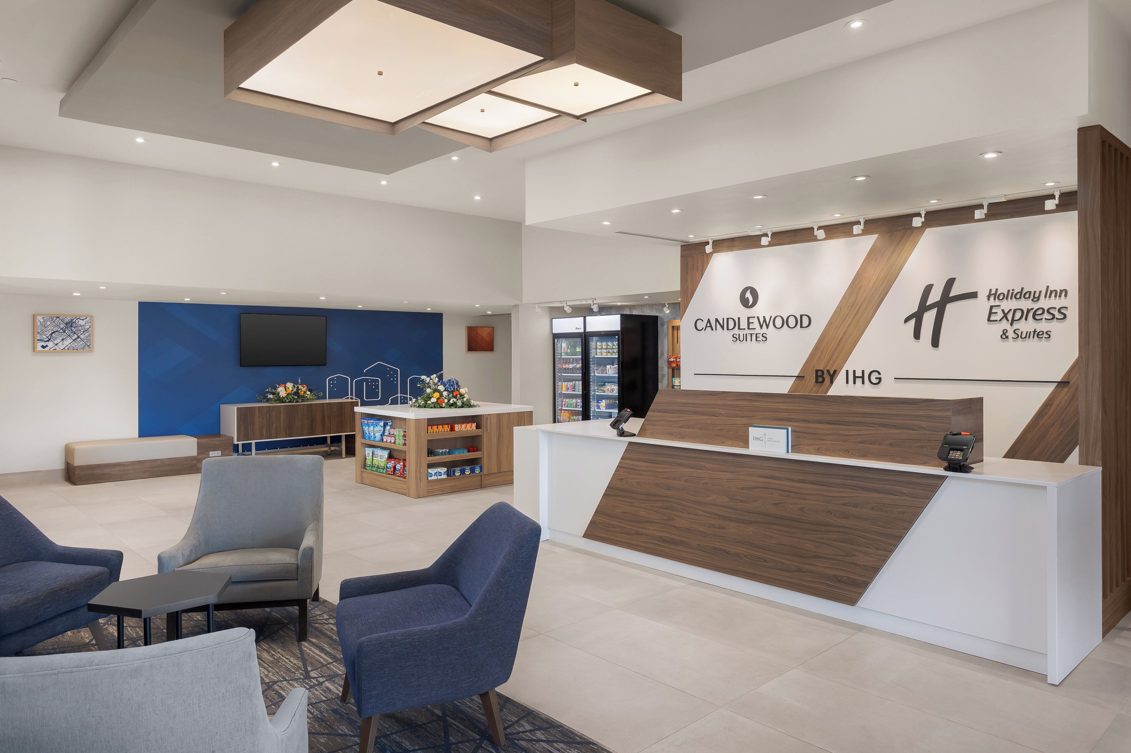 Ein Hotel-Empfangsbereich mit modernem Design, inklusive einer Rezeption, einer Sitzecke und einer Präsentation der Annehmlichkeiten.
