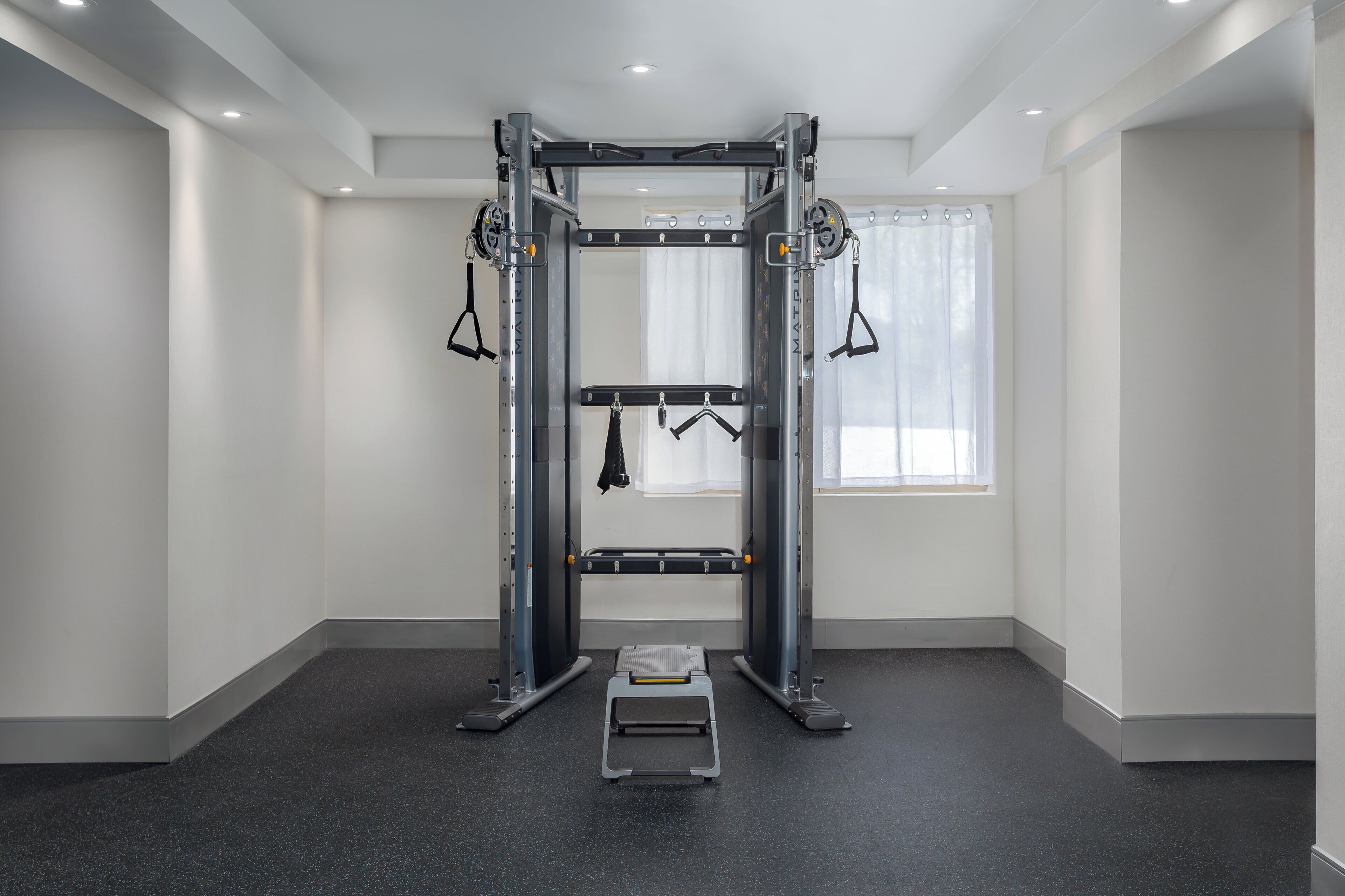 A gym with a pull-up bar, a bench, and a step platform.