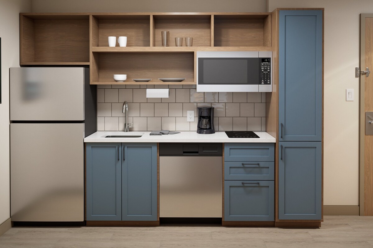 Una cocina moderna con microondas integrado, cafetera y lavavajillas.