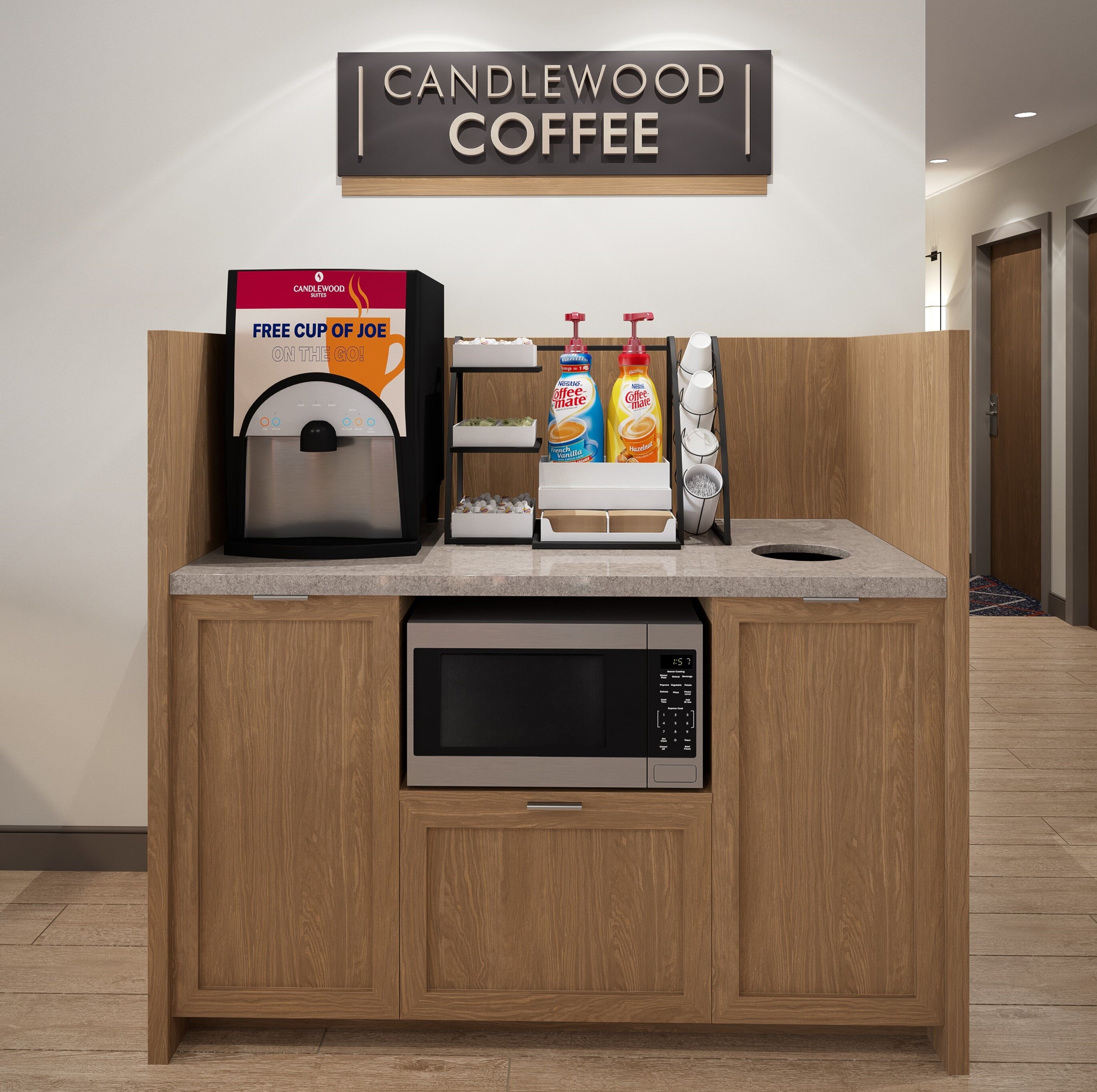 A coffee station with a coffee machine, a sign for Candlewood Coffee, and a free cup offer.