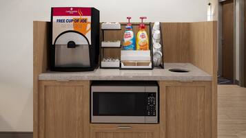 A coffee station with a coffee machine, a sign for Candlewood Coffee, and a free cup offer.