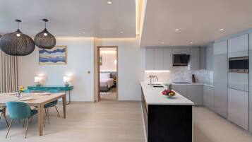 A modern kitchen with a marble countertop, a built-in oven, and a sink.