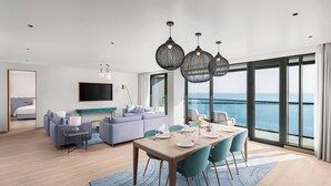 A modern hotel room with a balcony, a dining area, and a living space. - voco Muscat Al Mouj by IHG (Muscat)