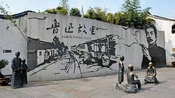 Une fresque ornée de caractères chinois et représentant une scène traditionnelle.