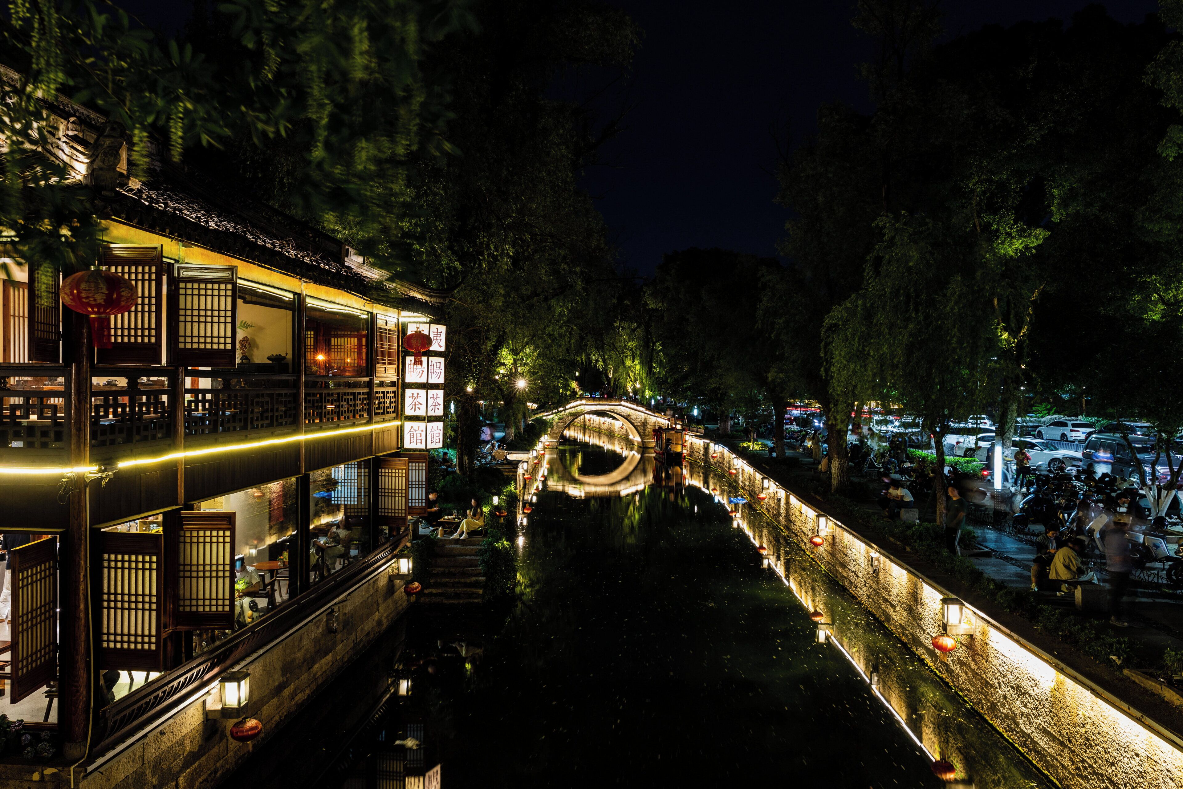 Un edificio tradicional de varios niveles, un puente y un río.