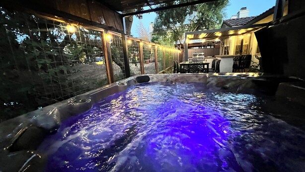A hot tub with a view of a patio area and a building in the background. - Charming Wine Country Retreat on the Napa-Yountville Border (Napa)