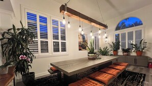 Una cucina moderna con isola centrale, sedute integrate e illuminazione a sospensione.