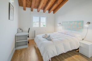 A bedroom with a bed, a desk, a chair, a radiator, a window, and a wall art piece. - Holiday Home 'Las Natillas Con V' with Mountain Views, Private Terrace and Wi-Fi (Martín Miguel)