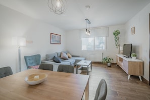 Un salon moderne avec un canapé, une table à manger et un meuble pour la télévision.