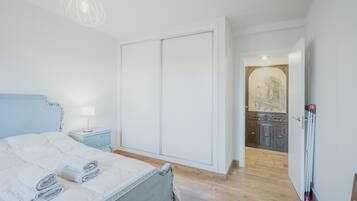 A bedroom with a bed, bedside table, and a wardrobe.