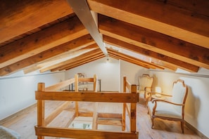 A wooden attic room with a sloped ceiling, wooden beams, and a small table with chairs. - Holiday Home 'Las Natillas Con V' with Mountain Views, Private Terrace and Wi-Fi (Martín Miguel)