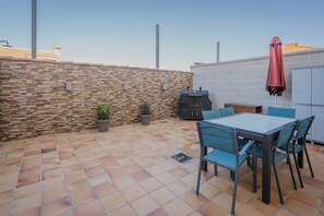 A patio with a table and chairs, a barbecue grill, and potted plants. - Holiday Home 'Las Natillas Con V' with Mountain Views, Private Terrace and Wi-Fi (Martín Miguel)