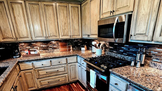 A kitchen with wooden cabinets, a granite countertop, stainless steel appliances, and a wooden floor. - “Relax, Unwind & Explore at Trailhead Hideaway – Mena’s Best Getaway!”

 (Mena)