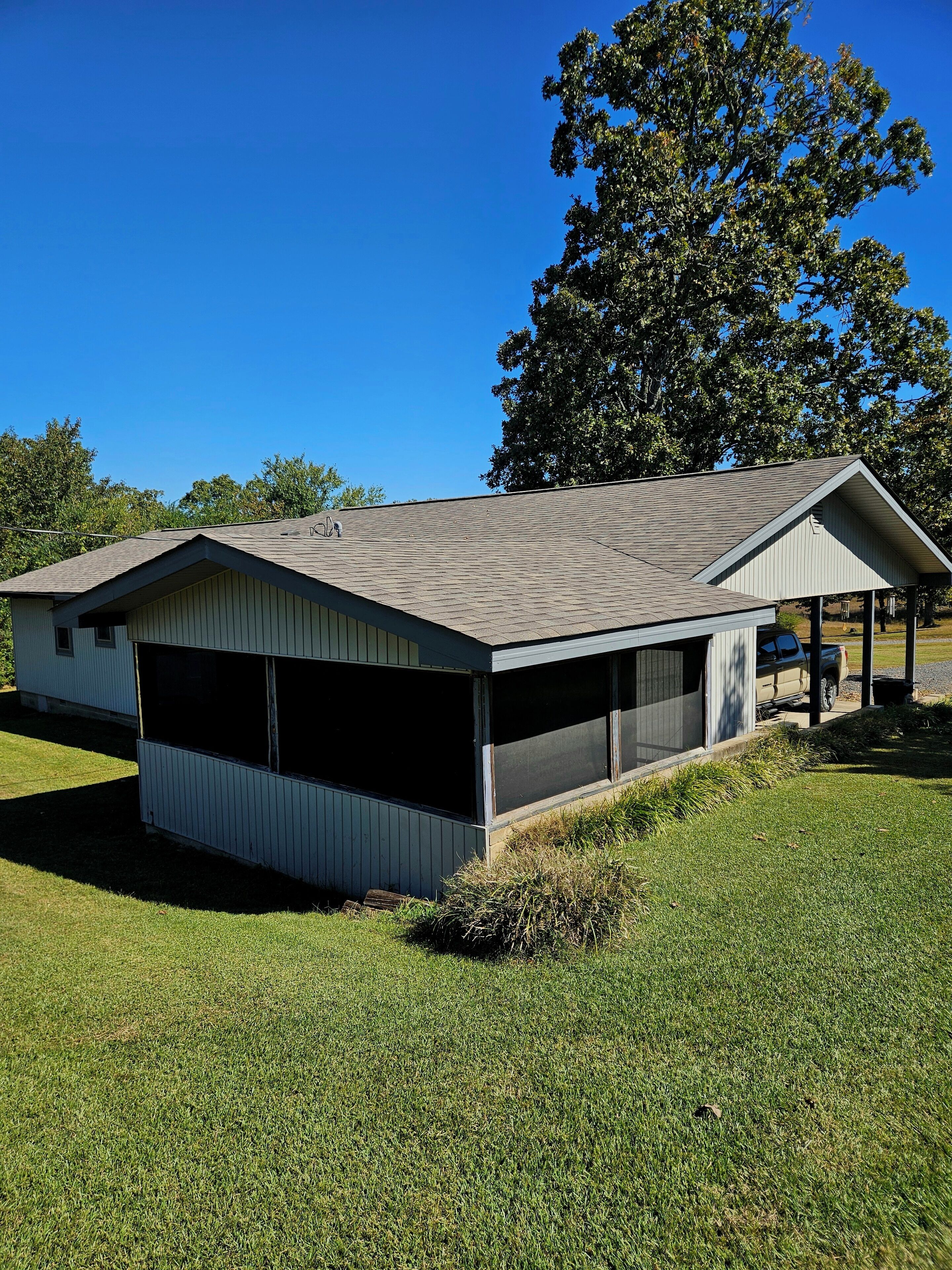 A single-story building with a covered garage and a small pavilion.