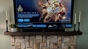 A flat-screen TV mounted on a stone fireplace wall, displaying a sports show. - “Relax, Unwind & Explore at Trailhead Hideaway – Mena’s Best Getaway!”

 (Mena)
