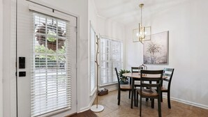 A dining area with a table and chairs, a chandelier, and a painting on the wall. - Beautiful 3 Bedroom On The River! (Vestavia Hills)