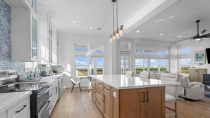 Una cocina amplia con una isla grande, armarios de madera y vistas al exterior.