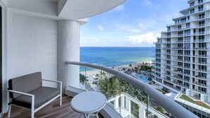 Un balcon avec vue sur l’océan et un bâtiment d’hôtel.