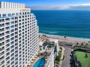 A high-rise hotel with a pool and beach view.
