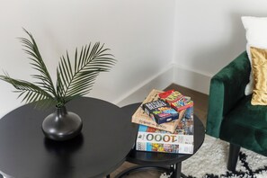 Ein kleiner Tisch mit einem Blumentopf und einer Sammlung Brettspiele.