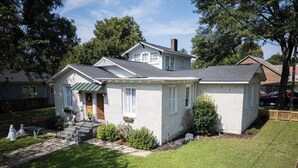 Une maison de plain-pied avec un porche à l’avant, un petit jardin et un garage bien visible.
