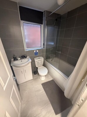 Ein Badezimmer mit Toilette, Waschbecken und Dusche.