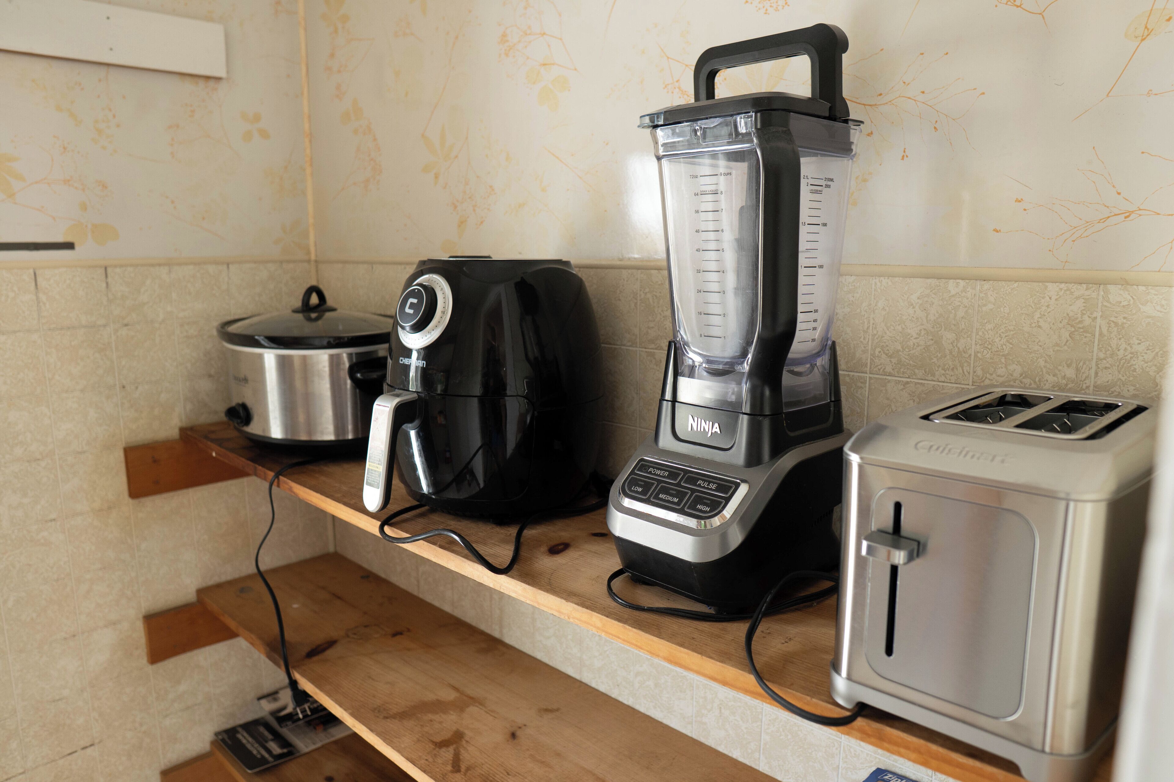 Una encimera de cocina con un tostador, una licuadora y una cafetera.