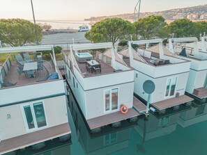 Un port de plaisance avec des maisons flottantes dotées d’un espace extérieur aménagé, d’un jacuzzi et d’une bouée de sauvetage.
