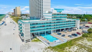 Ett hotell med pool, tillgång till stranden och en parkeringsplats.