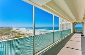 Een balkon met een helder uitzicht op het strand en de oceaan.