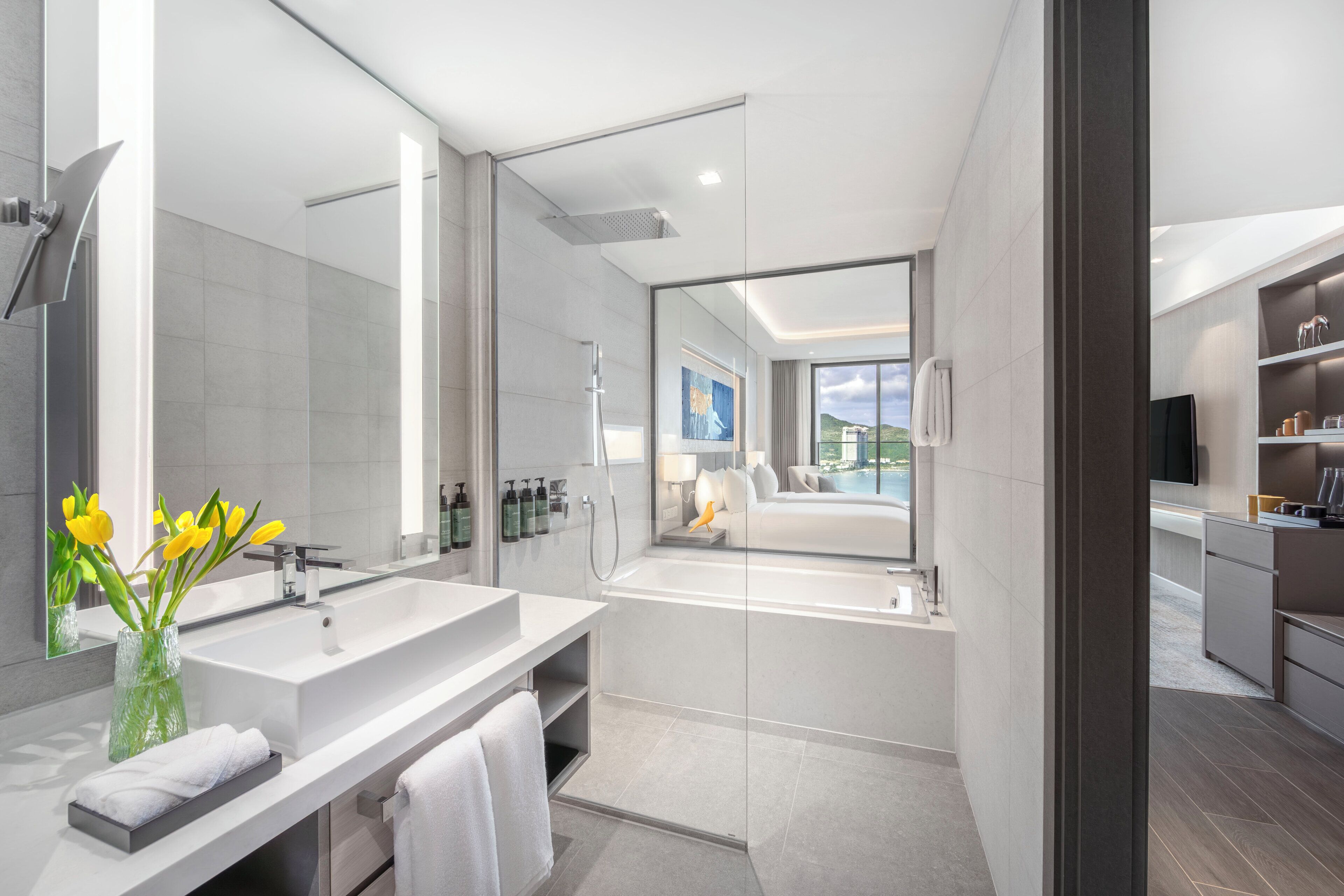 Ein modernes Badezimmer mit einem großen Spiegel, zwei Waschbecken, einer Badewanne und Blick auf einen Pool.