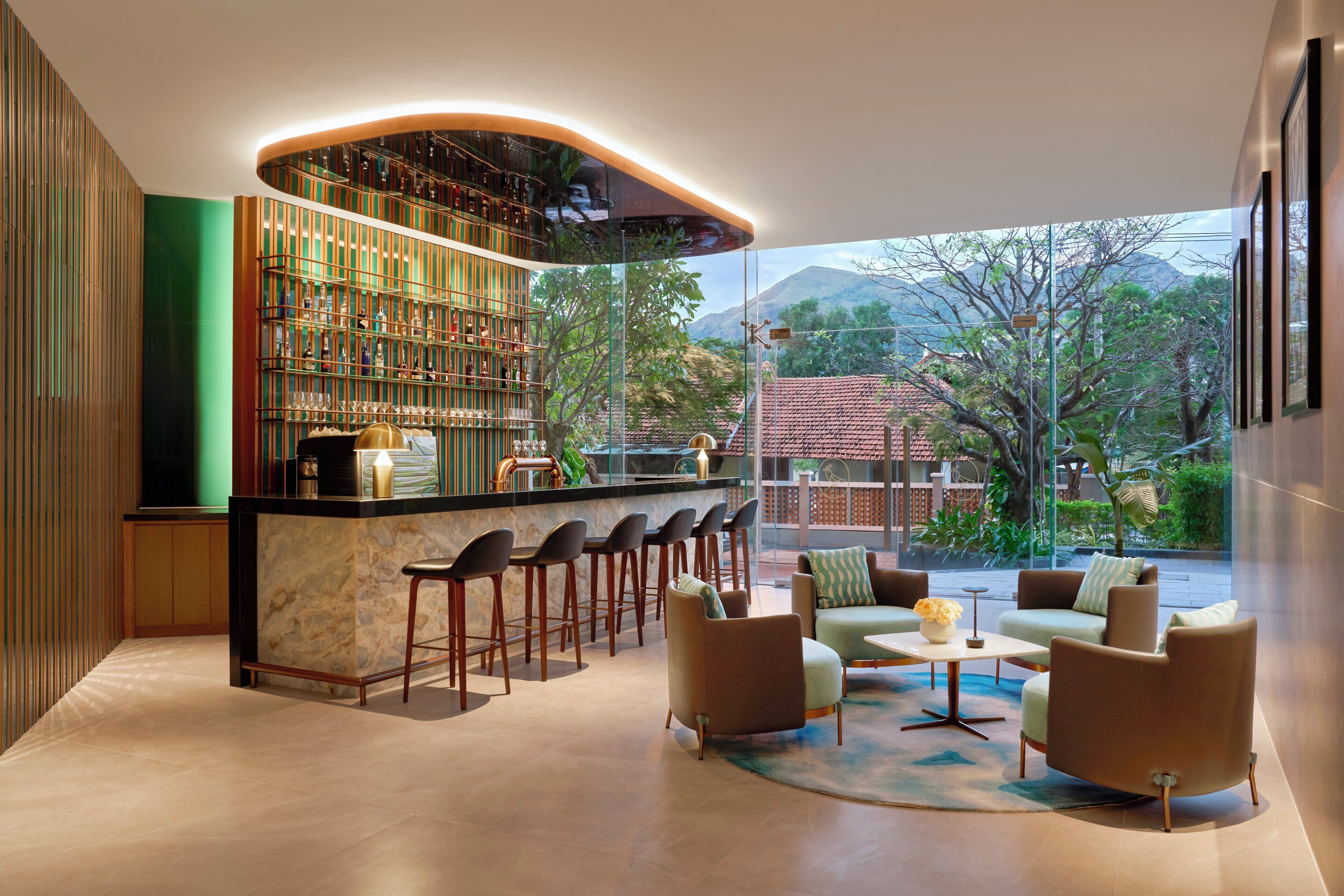 A bar area with a curved counter, multiple stools, and a seating area with sofas and a coffee table.