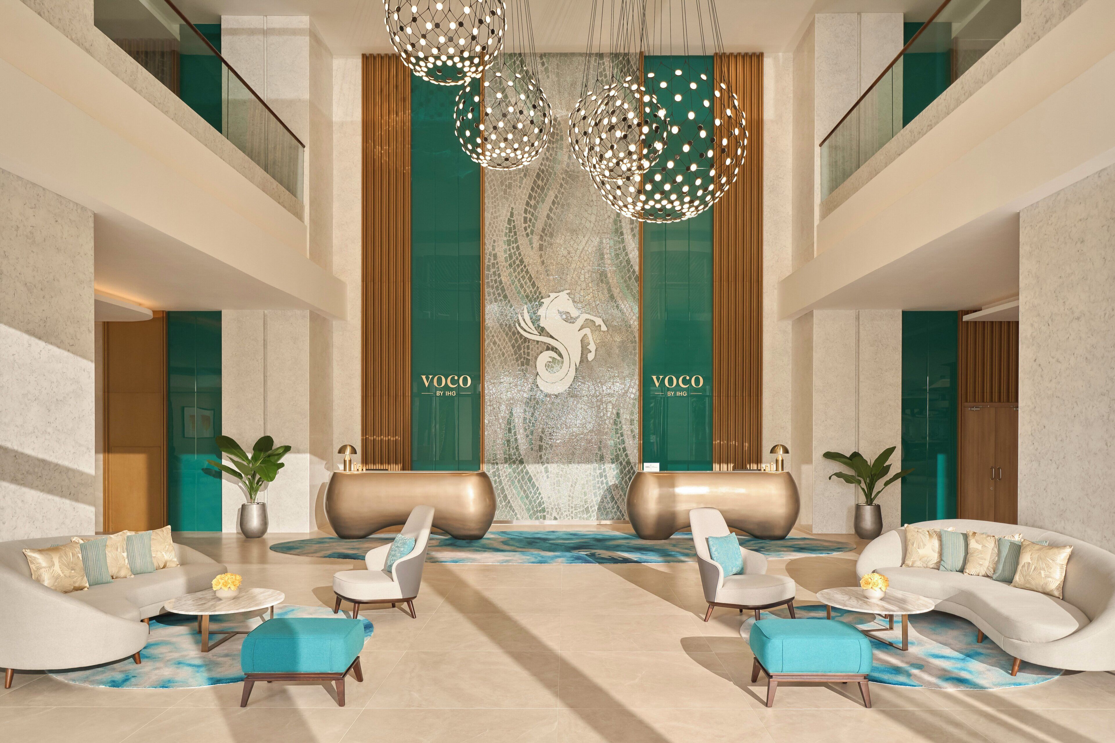 A modern lobby with a reception desk, seating area, and decorative lighting.