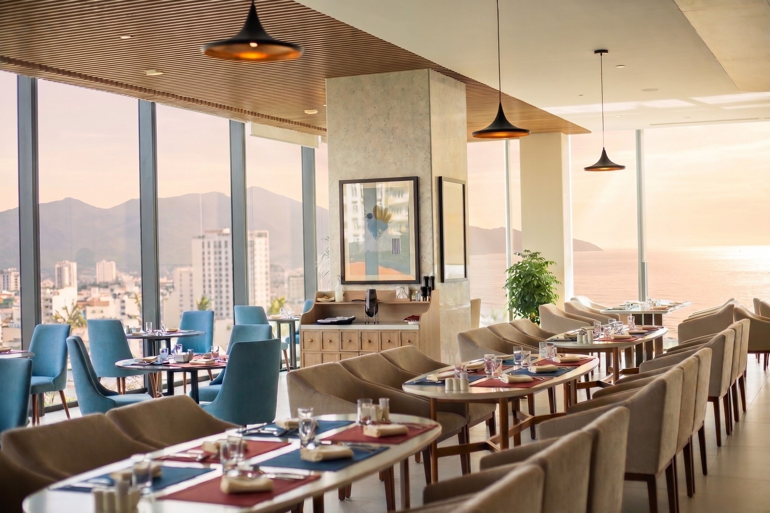 A restaurant with a city view, large windows, and modern furniture.