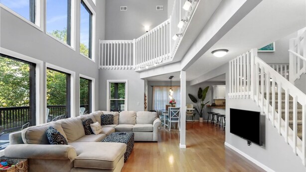 A spacious living area with a large sectional sofa, a dining table, and a kitchen area. - Deep Forest Dream- Aunt Susies Raystown Lake (James Creek)