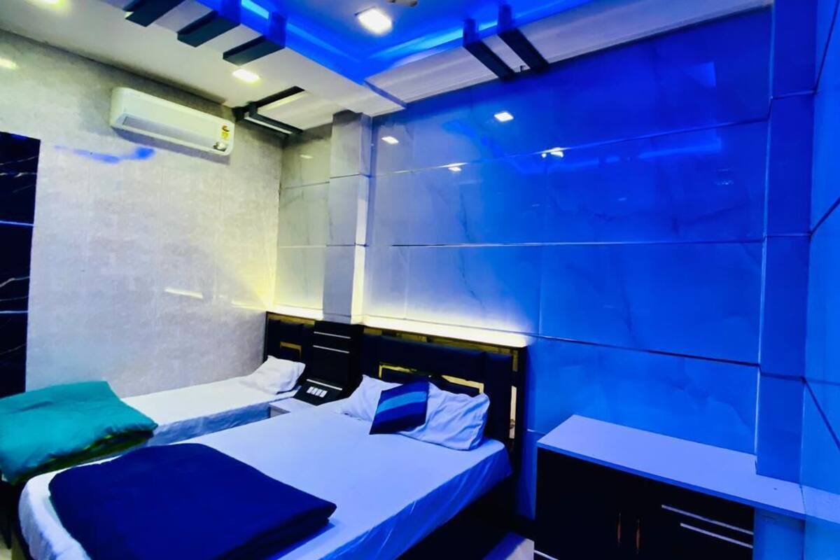Une chambre moderne avec un lit, des tables de chevet et un climatiseur fixé au mur.