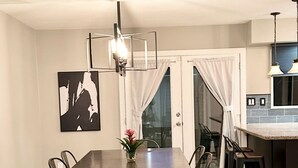 A dining area with a dark wooden table and chairs, a modern pendant light, and a decorative piece on the wall. - Rare 4 Bedroom Townhome with Backyard in Tempe (Tempe)