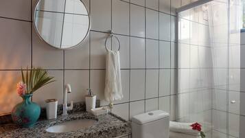 Chuveiro, toalhas de banho, papel higiênico