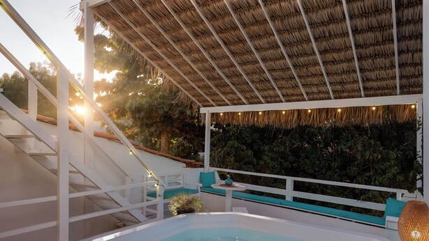 A hot tub under a thatched roof, surrounded by white railings and a staircase. - Pousada Casa Cecilia (Jijoca de Jericoacoara)