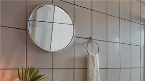 A bathroom with a round mirror, a sink, a toilet, and a towel rack. - Pousada Casa Cecilia (Jijoca de Jericoacoara)