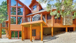 A log cabin with a balcony, large windows, and a stone chimney. - Hike, Fish & More: Grand Cabin w/ Decks in Sturgis (Sturgis)