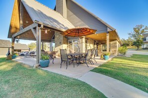 A covered patio with outdoor furniture and a large umbrella. - Upscale A-Frame Escape w/ Eufaula Lake Access! (Quinton)