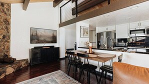 Una cocina moderna con armarios blancos, electrodomésticos de acero inoxidable y encimera negra.