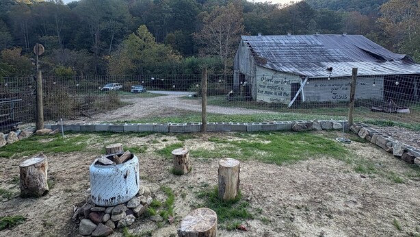A rustic cabin with a metal roof and a sign that reads "In the morning with Jesus."