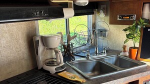 A compact kitchen with a stove, sink, and microwave.
